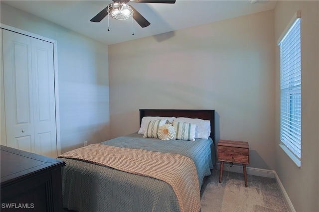 carpeted bedroom with a closet, baseboards, and a ceiling fan