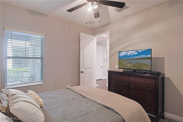 bedroom featuring a ceiling fan, visible vents, and baseboards