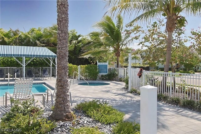 community pool featuring fence and a patio area