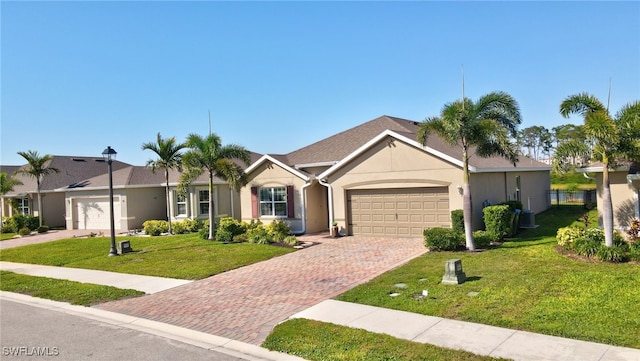 single story home with stucco siding, decorative driveway, an attached garage, and a front lawn