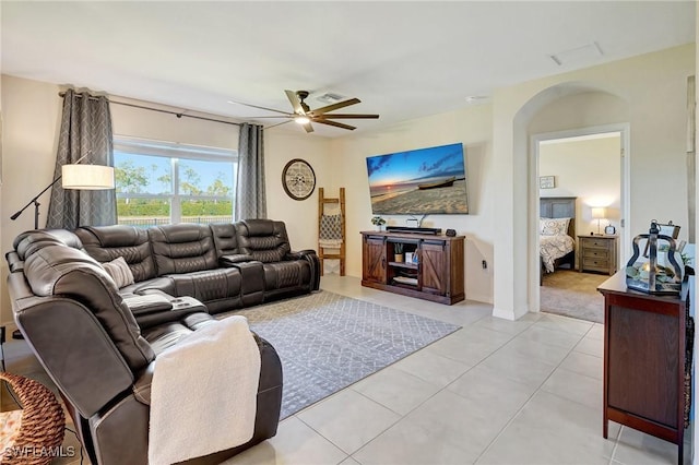 living room with light tile patterned floors, visible vents, and ceiling fan