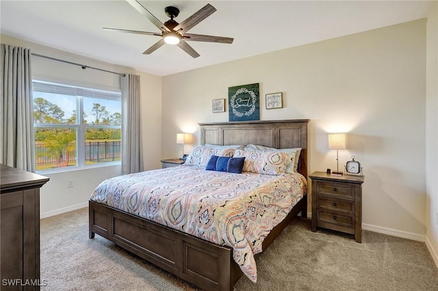 bedroom featuring light colored carpet, baseboards, and ceiling fan