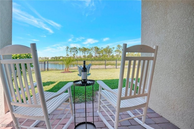 deck featuring a water view, a lawn, and fence