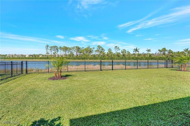 view of yard with a fenced backyard and a water view