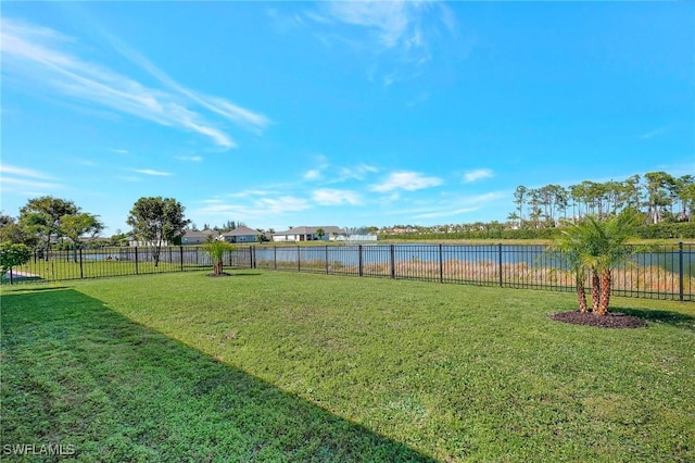 view of yard featuring a water view and a fenced backyard