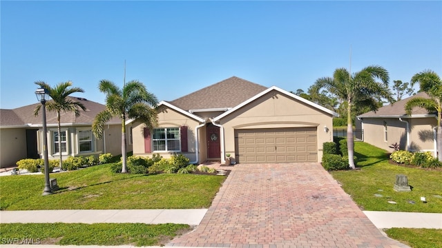 ranch-style home featuring stucco siding, an attached garage, decorative driveway, and a front yard