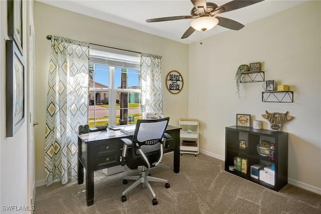 carpeted home office featuring baseboards and ceiling fan