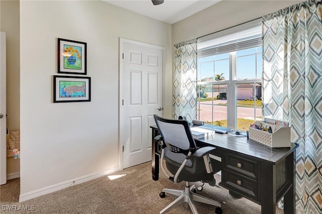 carpeted home office featuring baseboards