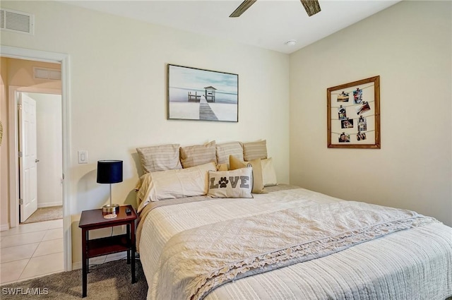 bedroom with light tile patterned floors, visible vents, light carpet, and a ceiling fan