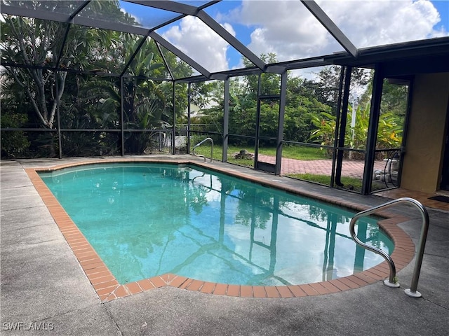 outdoor pool featuring glass enclosure and a patio area