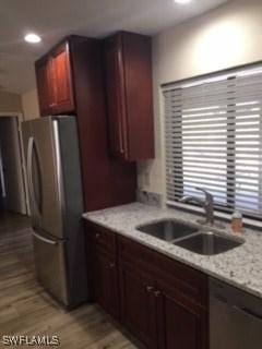 kitchen with a sink, stainless steel appliances, and light wood-type flooring