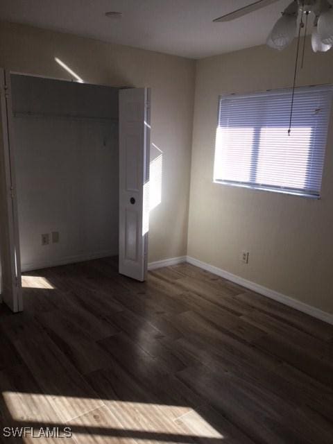 unfurnished bedroom with ceiling fan, baseboards, and wood finished floors