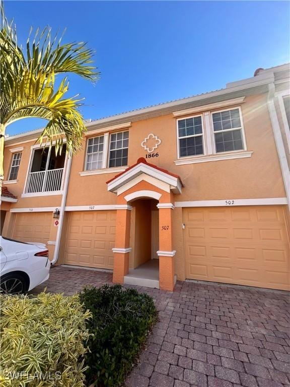 view of property featuring stucco siding, driveway, and an attached garage