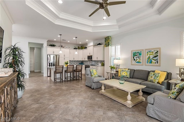 living area with recessed lighting, a ceiling fan, crown molding, and a tray ceiling