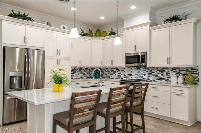 kitchen with a sink, backsplash, appliances with stainless steel finishes, and crown molding