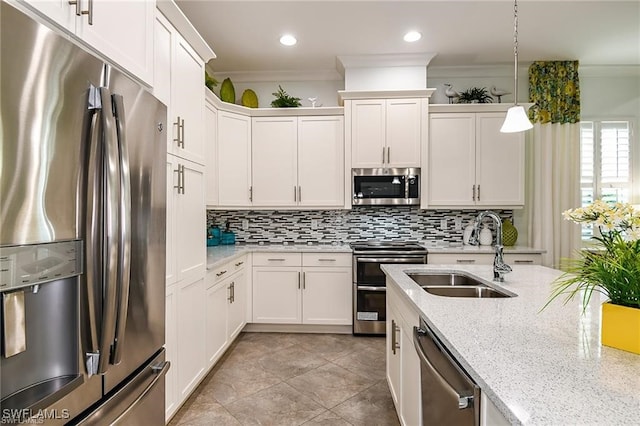 kitchen with a sink, stainless steel appliances, tasteful backsplash, and ornamental molding