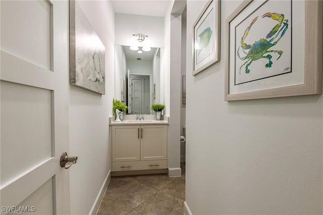 hall featuring a sink and baseboards