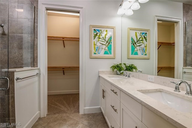 bathroom featuring a shower stall, double vanity, tile patterned floors, and a sink