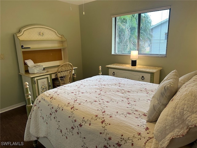 bedroom featuring baseboards and wood finished floors