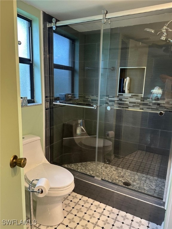 full bath featuring a shower stall and toilet