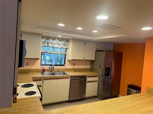 kitchen featuring a sink, a raised ceiling, visible vents, and stainless steel appliances