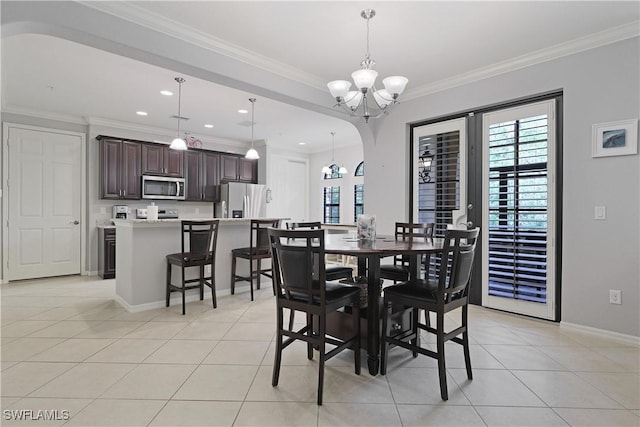 dining area with light tile patterned floors, a wealth of natural light, a chandelier, and crown molding