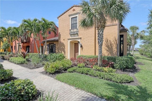 mediterranean / spanish-style house with stucco siding and a balcony