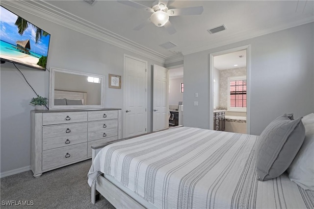 carpeted bedroom with visible vents, crown molding, baseboards, ensuite bath, and a ceiling fan