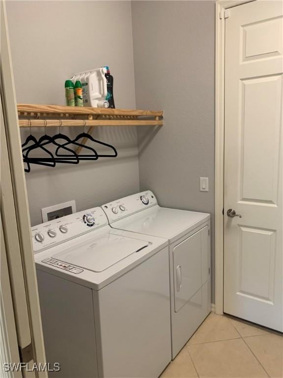 laundry room with light tile patterned flooring, laundry area, and washing machine and clothes dryer