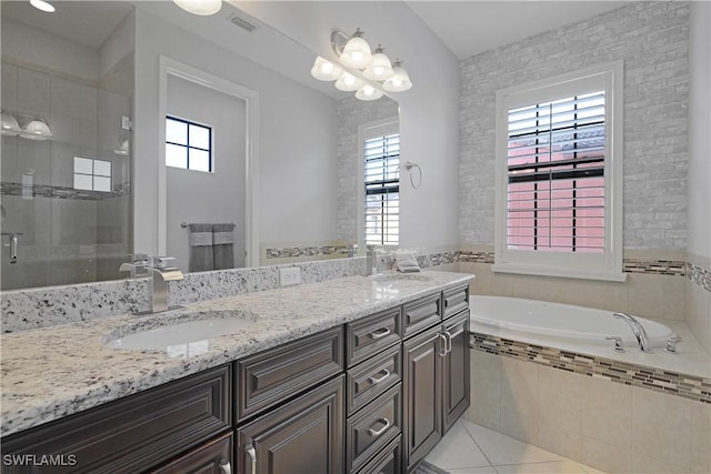 bathroom with a sink, a healthy amount of sunlight, a stall shower, and tile patterned flooring