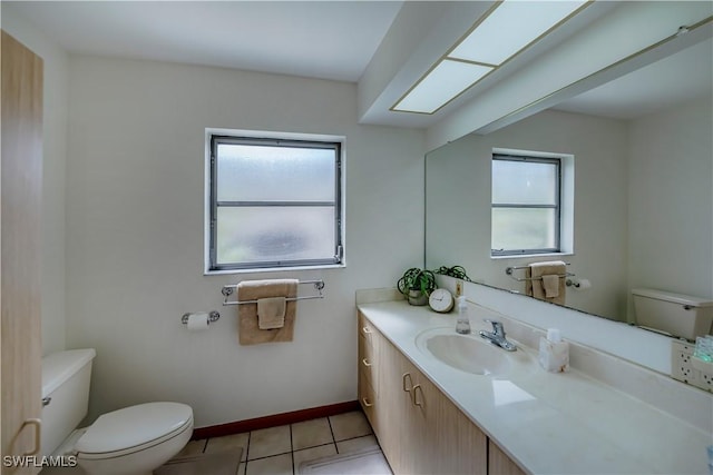 bathroom with tile patterned flooring, toilet, vanity, and baseboards