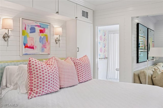 bedroom featuring wooden walls and visible vents