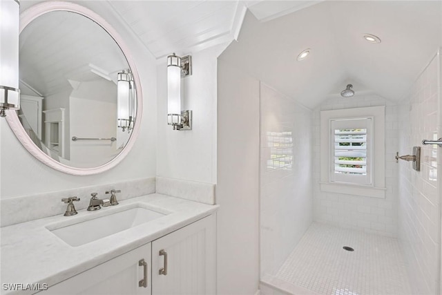 bathroom with recessed lighting, vanity, a tile shower, and vaulted ceiling