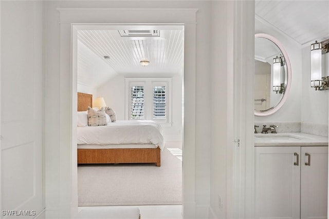 bedroom with vaulted ceiling and a sink