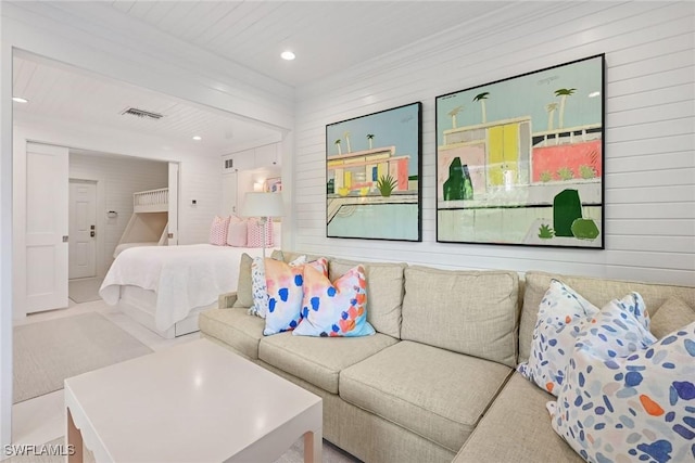 living room with visible vents, recessed lighting, and wooden walls