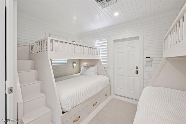 bedroom with visible vents, wood ceiling, wood walls, and ornamental molding