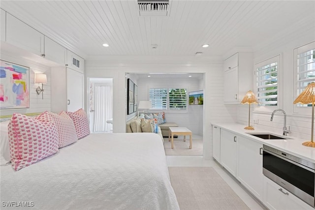 bedroom with visible vents, multiple windows, wooden ceiling, and a sink