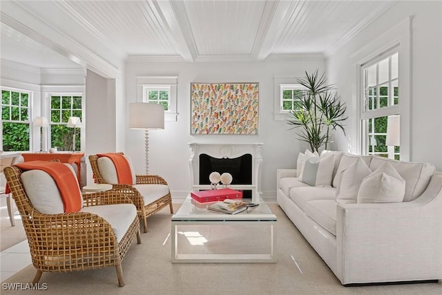 living area featuring beam ceiling, a fireplace, baseboards, and ornamental molding