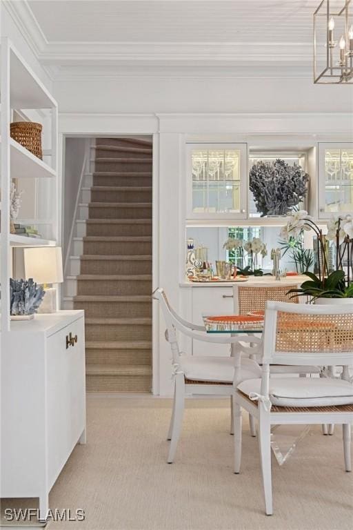 dining area featuring stairway, breakfast area, an inviting chandelier, and ornamental molding