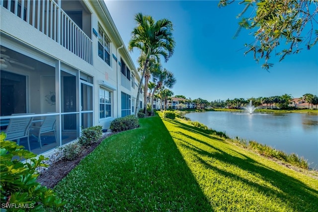 exterior space featuring a lawn and a water view