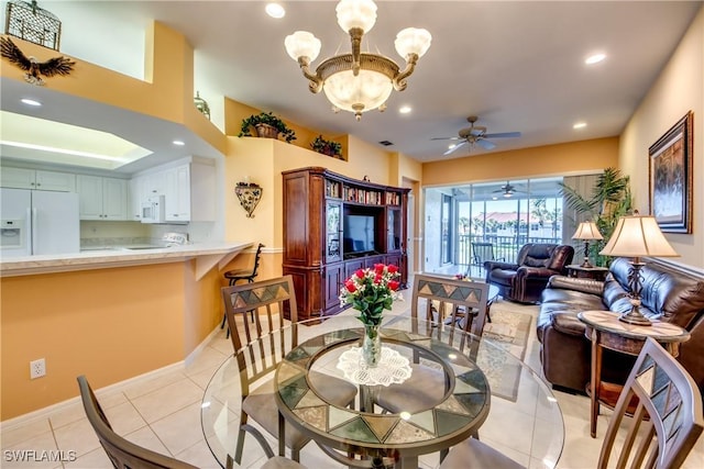 dining space with light tile patterned floors, recessed lighting, ceiling fan with notable chandelier, and baseboards