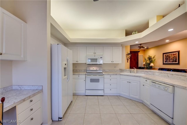 kitchen featuring white appliances, light tile patterned floors, a sink, light countertops, and white cabinets