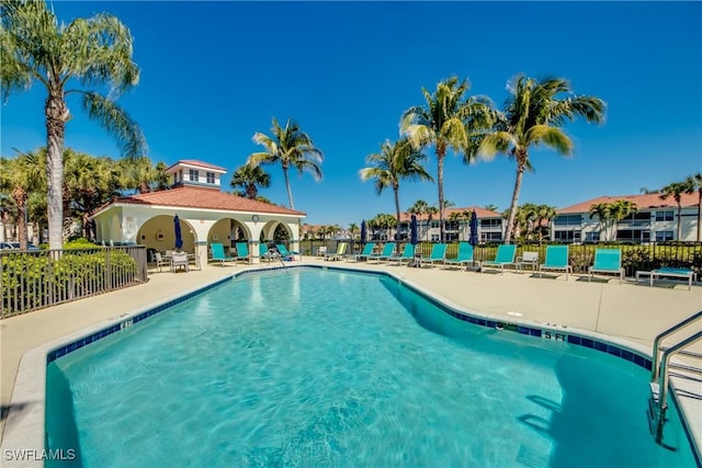 pool with a patio and fence