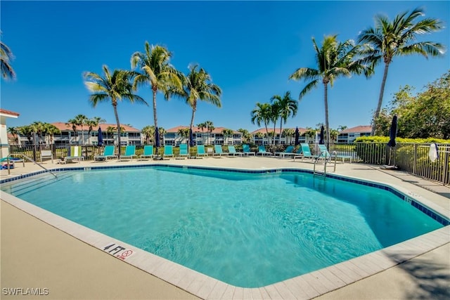 pool with a patio area, a residential view, and fence