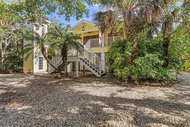 view of front of house with covered porch, ceiling fan, and stairs