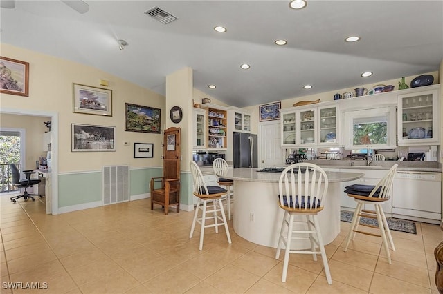 kitchen with visible vents, freestanding refrigerator, vaulted ceiling, light countertops, and dishwasher