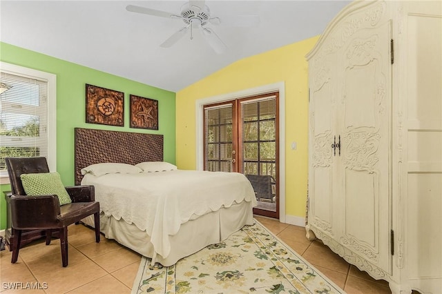 bedroom with vaulted ceiling, multiple windows, light tile patterned floors, and ceiling fan