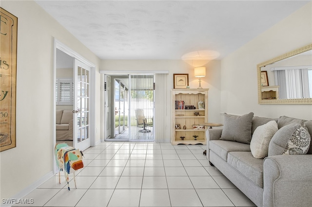 living room with light tile patterned floors, french doors, and baseboards