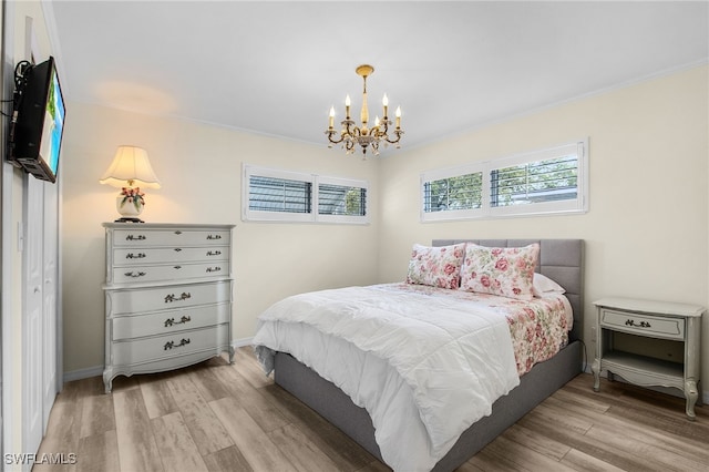 bedroom with crown molding, a notable chandelier, and wood finished floors