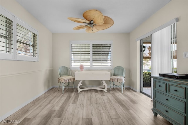 sitting room with a ceiling fan, baseboards, and light wood-type flooring